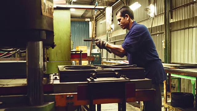 工厂工人将原材料放到机器上进行生产视频下载