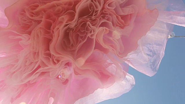 站在复古的粉红色鸡尾酒裙与蓝天的背景下视频素材
