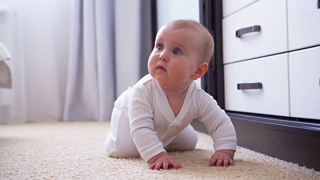 婴儿在地板上爬向摄像机视频素材