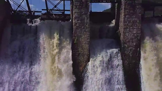 鸟瞰图。瀑布和老水坝的镜头。夏天的风景。摄像机从左向右移动视频素材