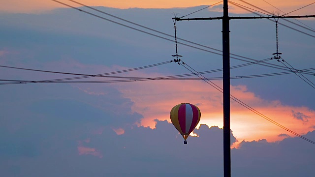 气球逆着夕阳的背景飞行，多云的天空，不寻常的旅程视频素材