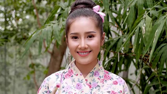 一个美丽的亚洲女人的肖像对着相机灿烂的微笑视频素材