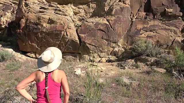 女人探索古老的岩画，怀俄明州传奇的岩石州考古遗址视频素材