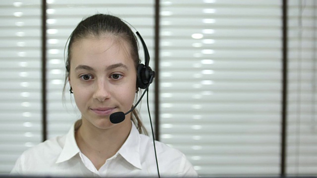 女商人戴着耳机在办公室里打电话视频素材