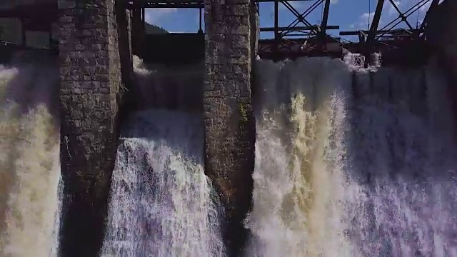 鸟瞰图。瀑布和老水坝的镜头。夏天的风景。摄像机从右向左移动视频素材