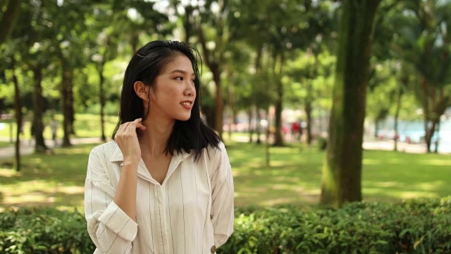 公园里美丽的年轻中国女人视频素材