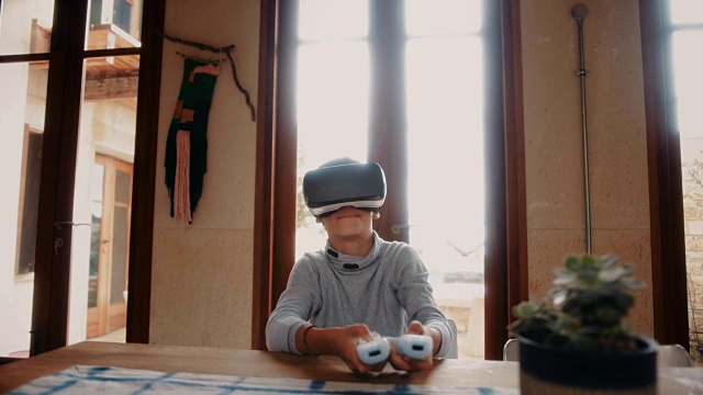 男孩戴着虚拟现实头盔在家玩电子游戏视频素材