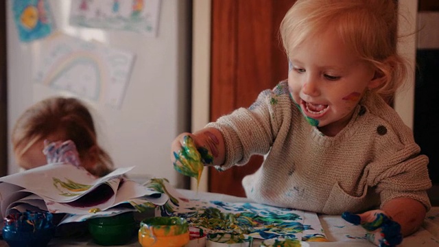 快乐的幼儿在家庭厨房里用手指画视频素材