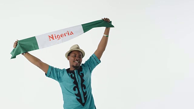 精力充沛的男足球迷举着尼日利亚国旗视频下载