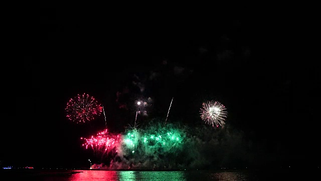 奇妙的多色烟花与烟雾从海上的大船上的夜空背景的4k镜头，庆祝概念视频素材