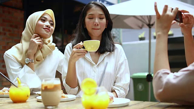 戴着头巾的女人和她的朋友在咖啡馆里聊天视频素材