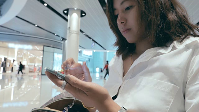 美丽的年轻女子迷人的近距离使用移动智能手机在购物中心视频素材