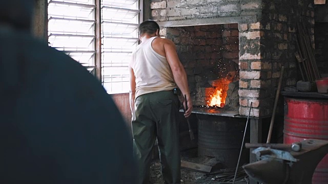 铁匠从火中取出铁棒视频素材