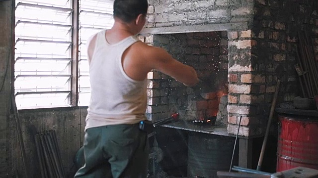 铁匠从火中取出铁棒，把水浇在铁和火上视频素材