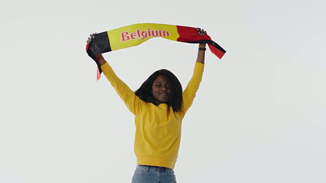 拿着比利时国旗的非洲女孩坐着跳着视频素材