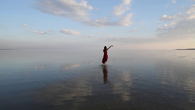 芭蕾舞演员穿着红色的衣服在湖上跳舞视频素材