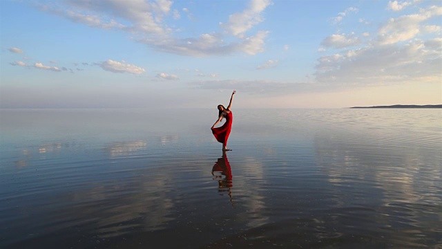 芭蕾舞演员穿着红色的衣服在湖上跳舞视频下载
