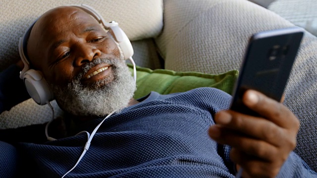 老人在客厅用手机听4k音乐视频素材