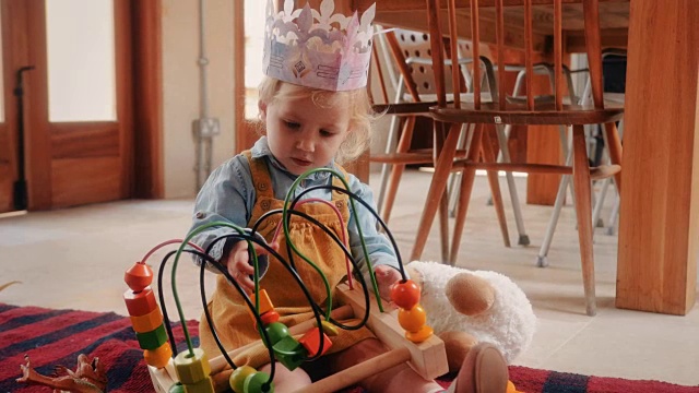 小女孩在厨房地板上玩木制玩具视频素材