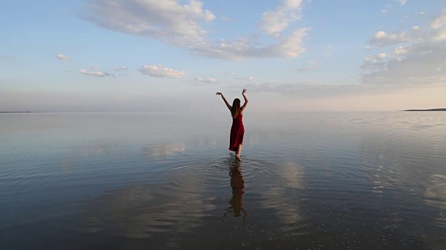 芭蕾舞演员穿着红色的衣服在湖上跳舞视频素材