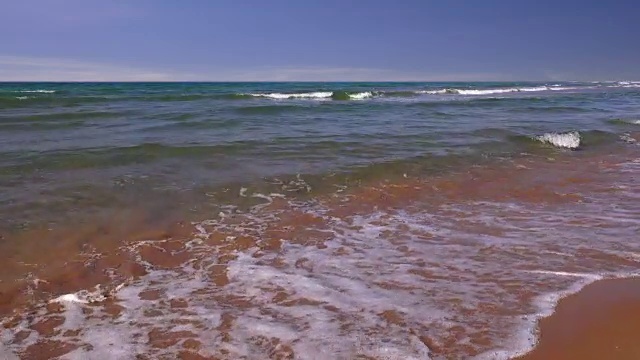 透明的波浪在沙滩上翻滚视频素材