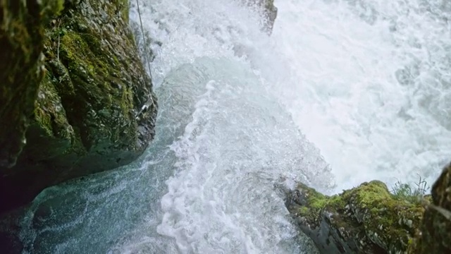 清澈的水冲下岩石床，创造了一个美丽的瀑布视频素材