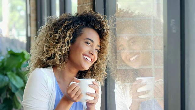 漂亮的年轻女子喜欢在家里喝一杯热咖啡视频素材