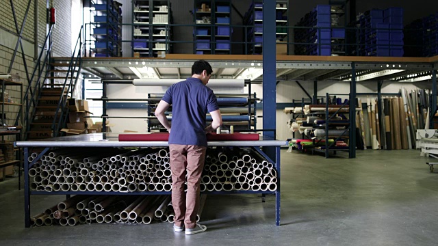男性在生产仓库测量织物视频素材