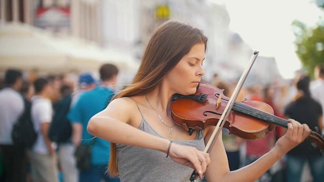 夏日的步行街上，年轻的女小提琴手在拉小提琴视频素材
