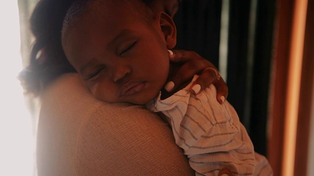 慈母抱着熟睡的小男孩视频素材