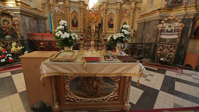在天主教教堂举行婚礼。美丽的教堂内部和一张桌子，上面有教堂的书，十字架，婚礼花冠，蜡烛视频素材
