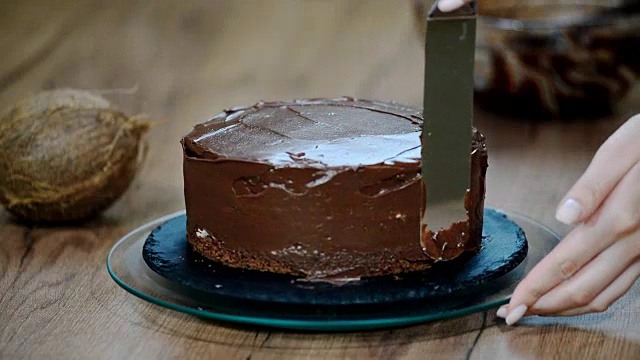 糕点师在蛋糕上涂上巧克力奶油。视频素材