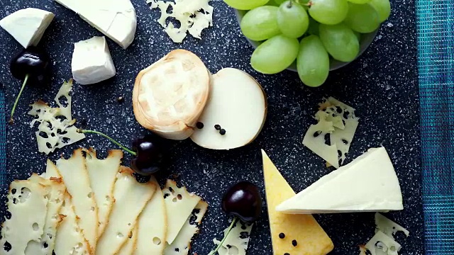 寒冷的开胃菜。冷盘。切菜板上的奶酪孤立在蓝色背景上，俯视图视频下载