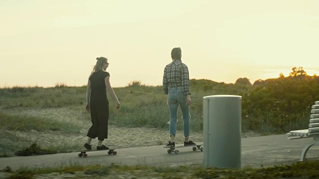 年轻女子在夕阳下玩滑板(慢镜头)视频下载