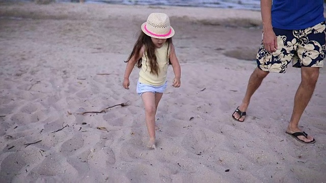 父亲和一个可爱可爱的女儿在海滩上视频素材