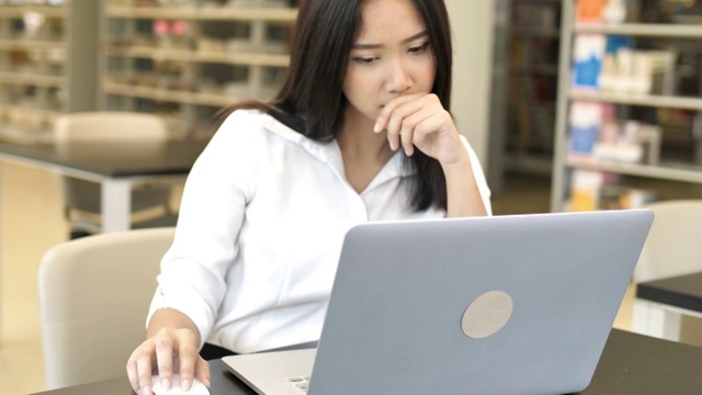 一名忧虑的亚洲商务女性使用笔记本电脑的慢镜头视频素材
