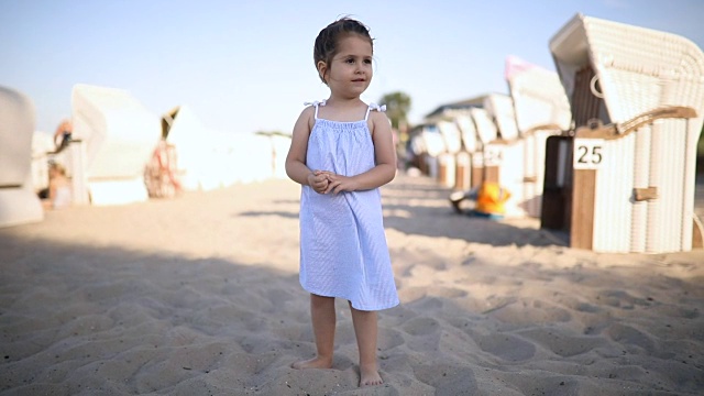 可爱的微笑的孩子站在海滩上视频素材