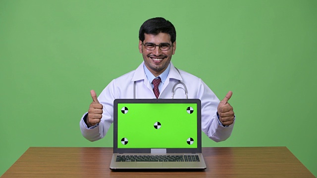 年轻英俊的波斯男子医生展示笔记本电脑视频下载