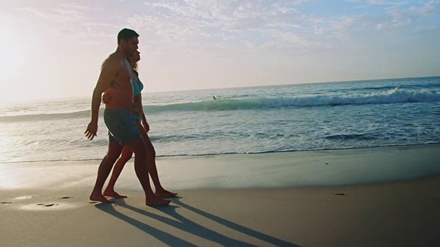 一对情侣在海滩上散步视频素材