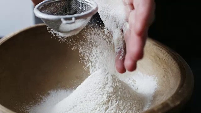 女人们用手在碗里筛面粉。视频素材