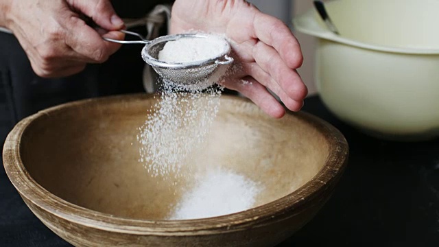 女人们用手在碗里筛面粉。视频素材
