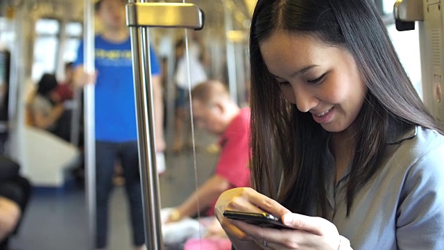 一名年轻女子在地铁上用智能手机查看地图视频素材