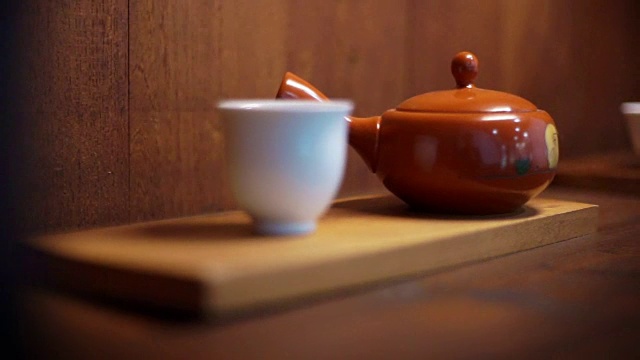 日本传统茶具。木制背景上的茶壶和茶杯。视频素材