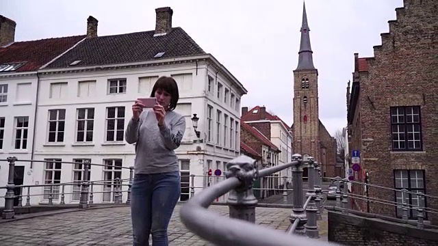 一名女游客在比利时布鲁日用智能手机拍照视频素材