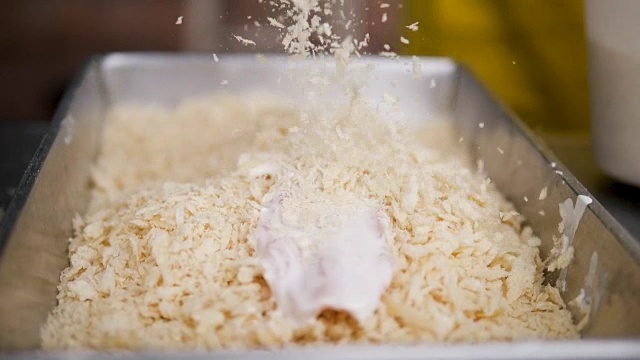 切好的鸡肉条在烹饪前与面包屑混合，慢动作。视频素材