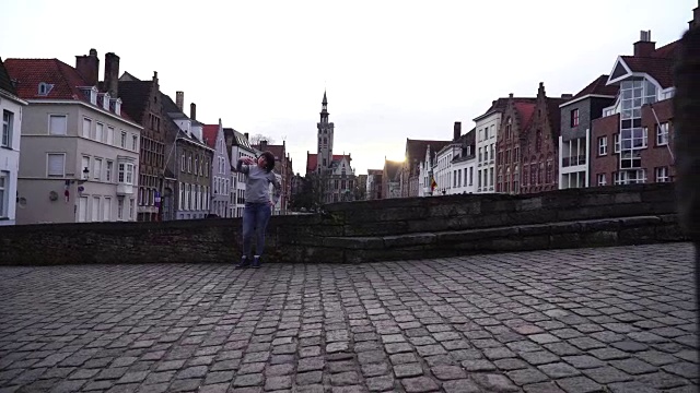 一名女游客在智能手机上自拍，背景是比利时布鲁日视频素材