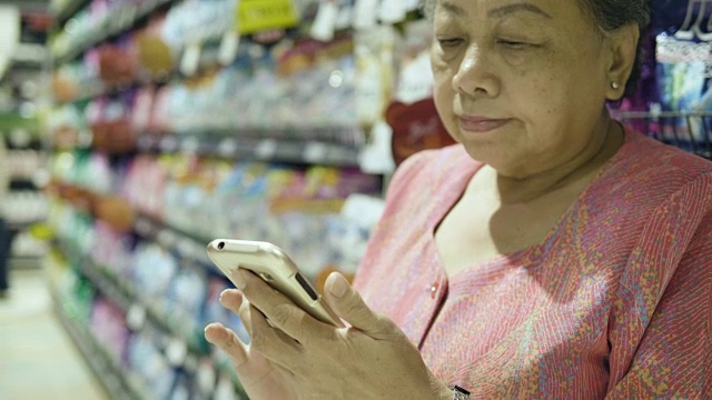 奶奶在超市用智能手机视频素材