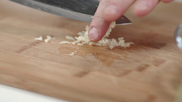 大厨用菜刀切碎蒜瓣的跟踪镜头视频素材