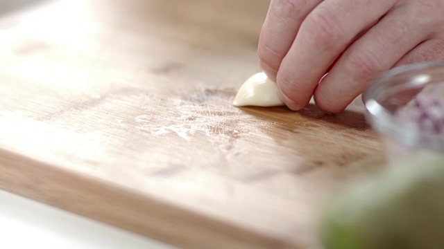 厨师将蒜瓣放在切菜板上视频素材