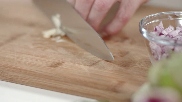 大厨用菜刀切蒜瓣的慢动作跟踪镜头视频素材